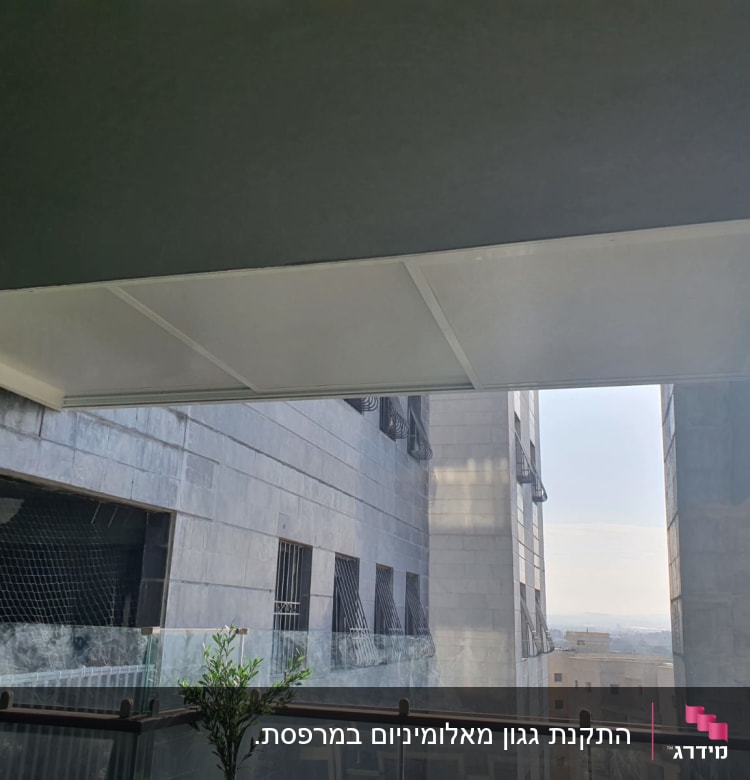 גג אלומיניום מעל מרפסת עם מעקה זכוכית